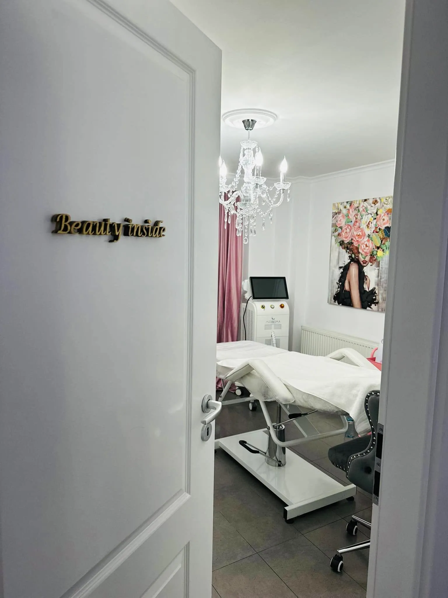 Ușa salonului, cu inscripția aurie „Beauty inside”, și patul de tratament