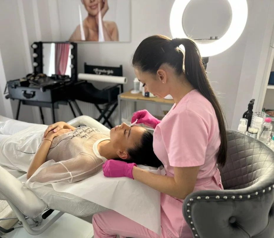 Iulia Duma lucrând la sprâncenele unei cliente, în salon
