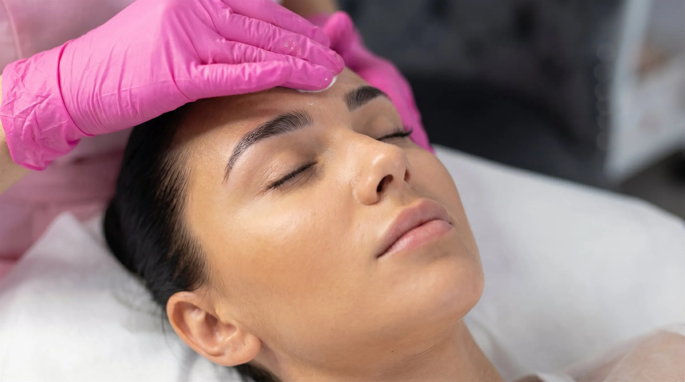 Tratament facial: curățarea tenului, cu mâinile Iuliei în mănuși roz